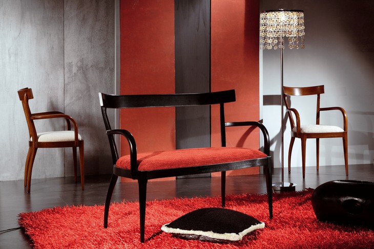 Divanetto classico in legno laccato nero, con la seduta rossa, fra due poltroncine