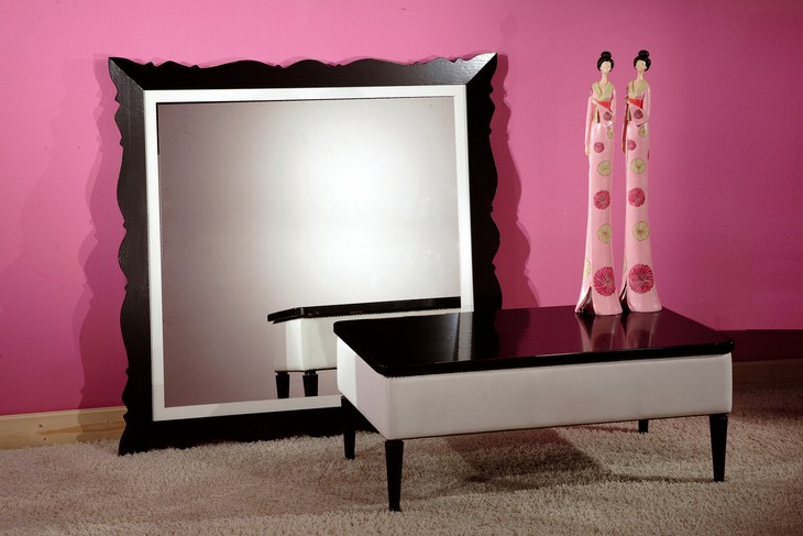 Tavolino classico in legno bianco e nero, basso, davanti a una specchiera grande
